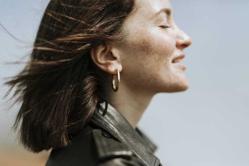 peelerie Side view of a woman in leather jacket standing in a park